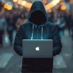 Rue de colmar en alsace avec un pirate informatique en capuche avec son ordi portable en pleine rue mis bine en évidence et derriere une foule de passant