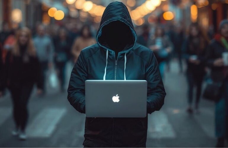 Rue de colmar en alsace avec un pirate informatique en capuche avec son ordi portable en pleine rue mis bine en évidence et derriere une foule de passant