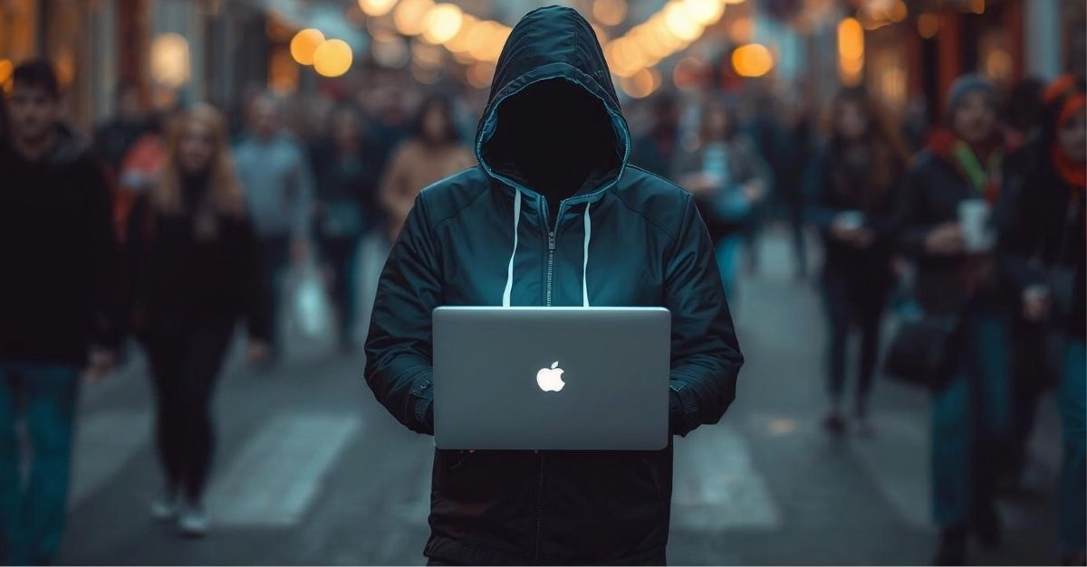 Rue de colmar en alsace avec un pirate informatique en capuche avec son ordi portable en pleine rue mis bine en évidence et derriere une foule de passant